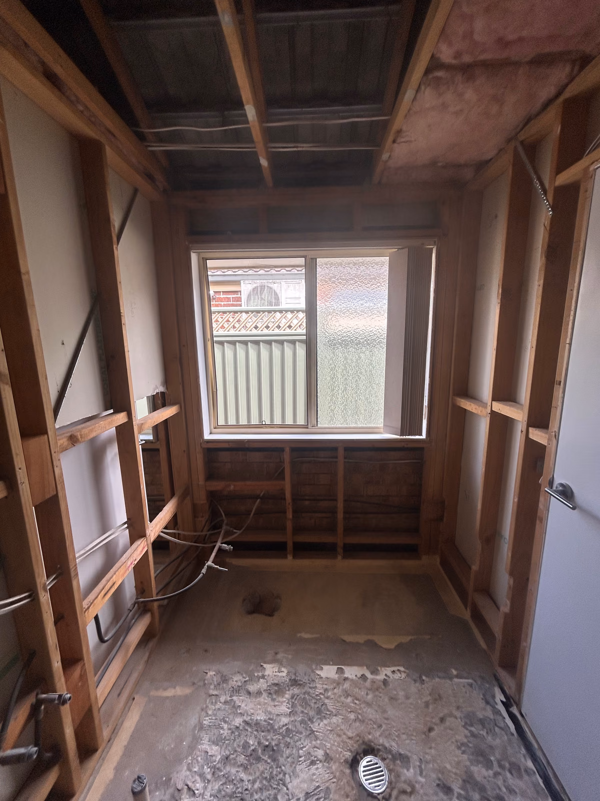 Bathroom after AJ strip-out, with fixtures and wall linings removed