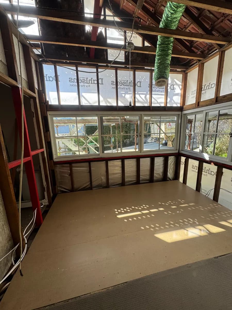 Exposed timber wall framing and a clear interior after sheeting removal