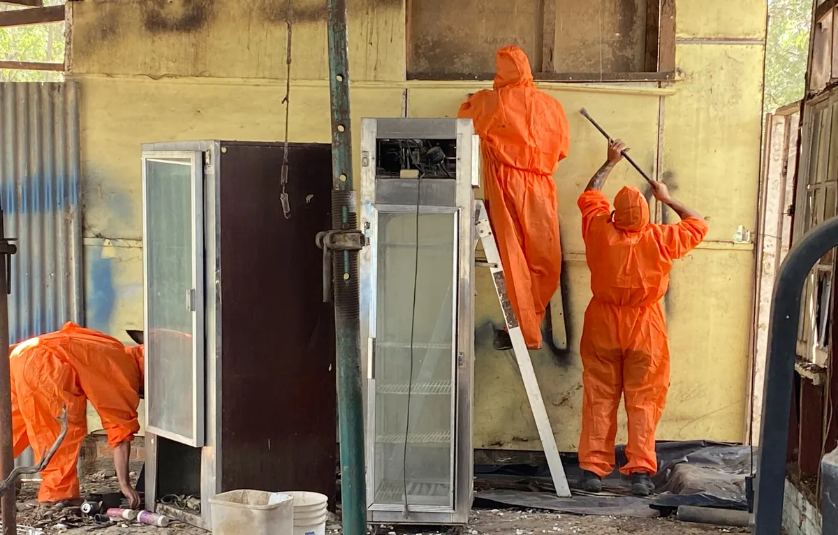 AJ crew in protective clothing removing interior wall sheeting