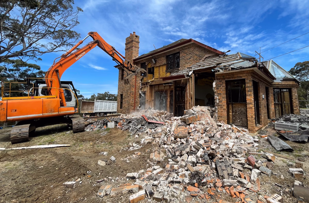 AJ excavator taking down a residential structure