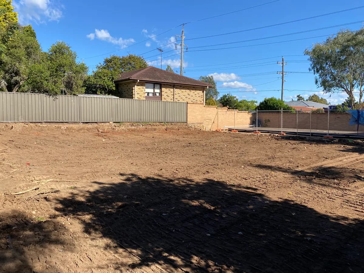 Cleared residential block with perimeter fences after AJ demolition work