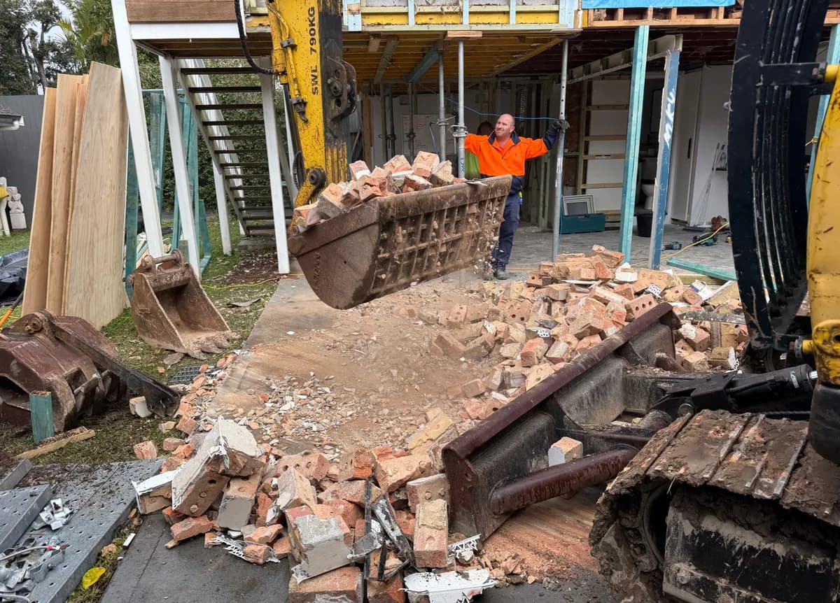 AJ crew removing brick walls and concrete in a restricted-access residential work area